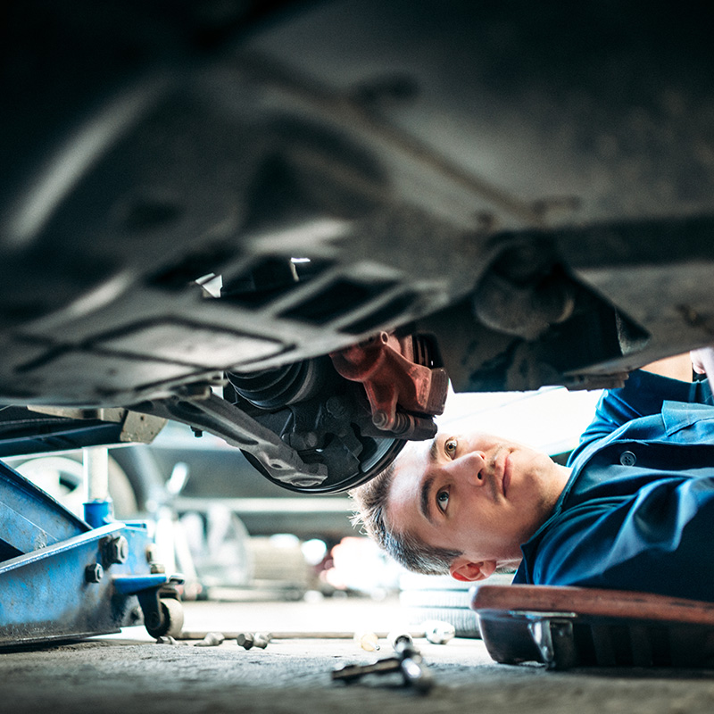 Car Mechanic Working Under Vehicle