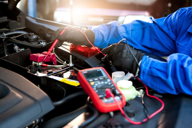 Under the hood of a car being tested for electrical repairs